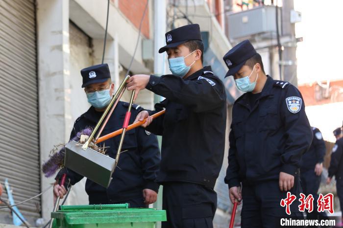 图为边检站民警将清理的垃圾装入垃圾桶，进行集中处理。　罗兴伟 摄